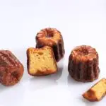 Canele or Cannele, French Pastry from Bordeaux. Rum and Vanilla Flavors with a Tender Custard Center and a Thick Caramelized Crust. Isolated on White background, Selective Focus